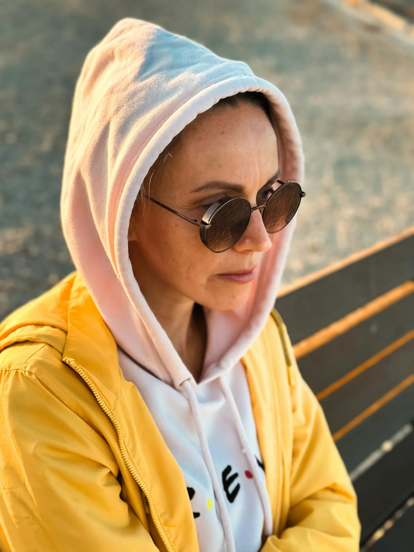 A woman in a yellow jacket and sunglasses