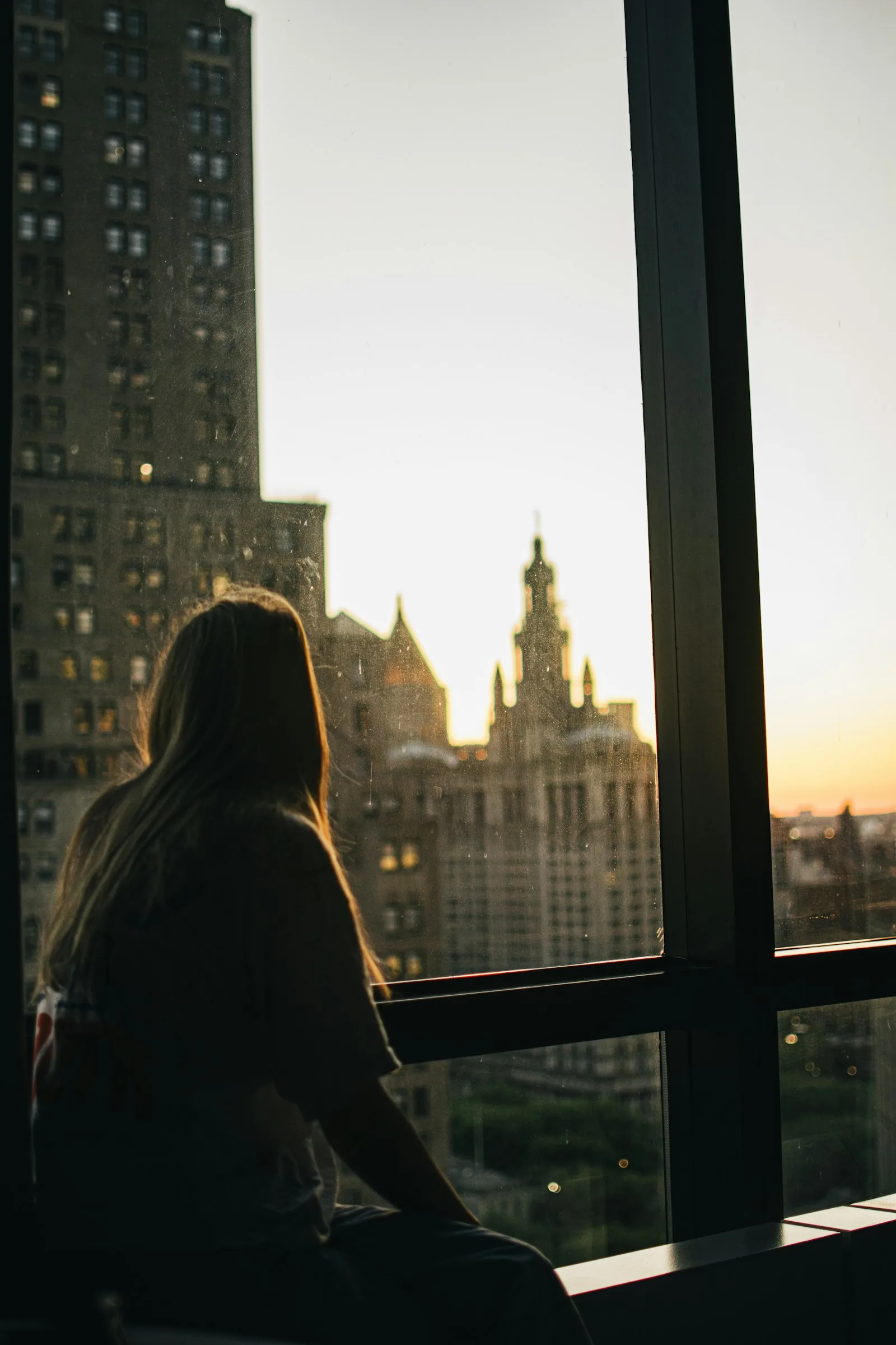 A silhouette at the window at dusk