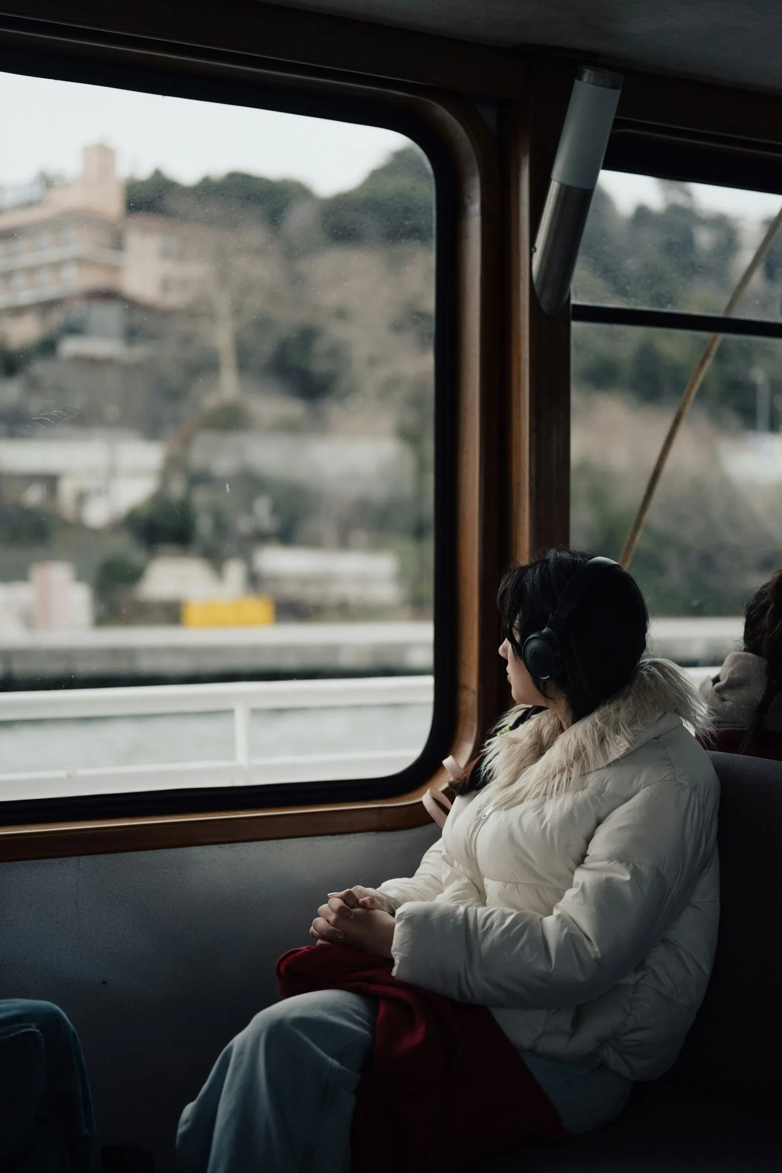 A woman at a window seat, looking out